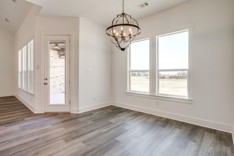 Unfurnished dining area with hanging lights, dark wood-type flooring, and a ceiling fan Unfurnished dining area with hanging lights, dark wood-type flooring, and a ceiling fan