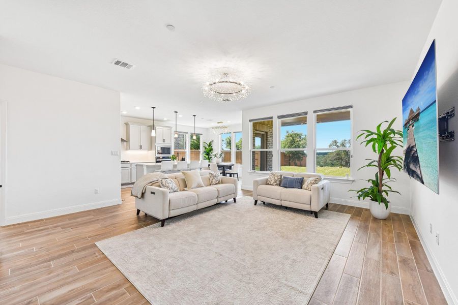 An open concept living area features recessed lighting and durable wood-look tile flooring.
