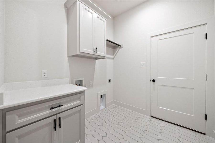 Laundry room with electric dryer hookup, hookup for a washing machine, and cabinet space