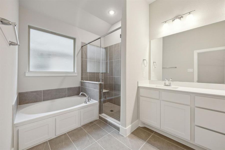 Bathroom featuring tile patterned floors, plus walk in shower, and vanity