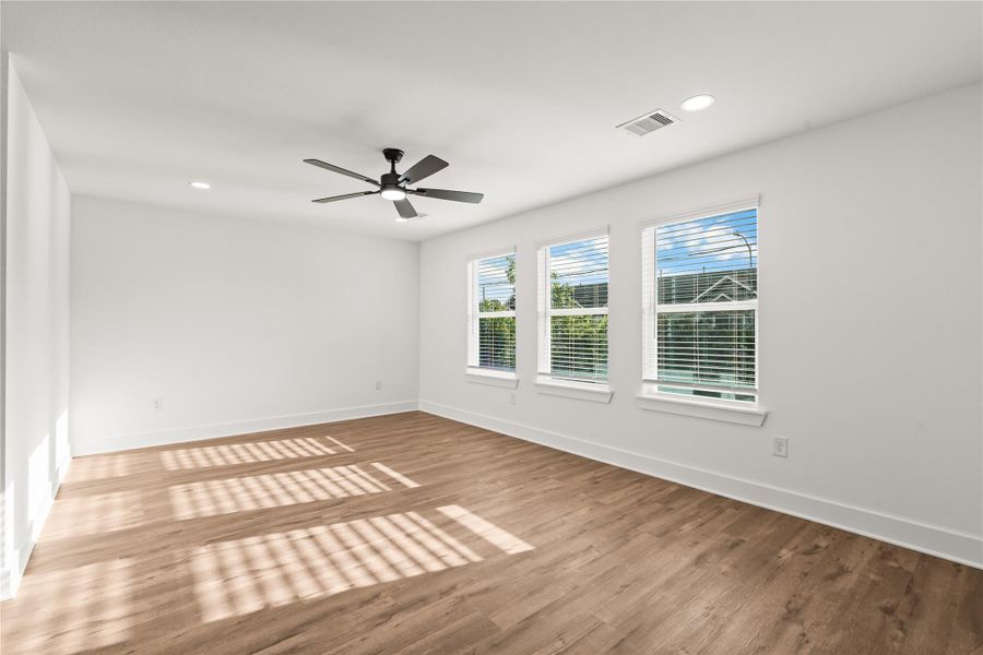 Wake up to natural light. The primary suite easily accommodates a king-size bed while three massive windows frame beautiful views of the neighborhood greenery.