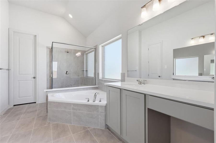 Modern bathroom featuring a corner soaking tub, a frameless glass shower enclosure with tile surround, and a dual vanity with a built-in dressing area