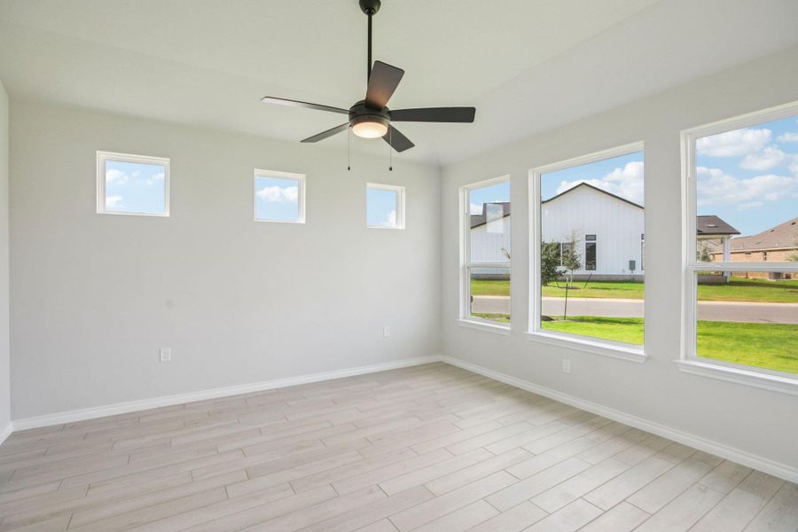 Empty room featuring light wood-style flooring and ceiling fan