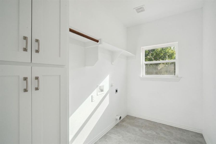 Washroom featuring hookup for a washing machine, light tile patterned floors, electric dryer hookup, and cabinets