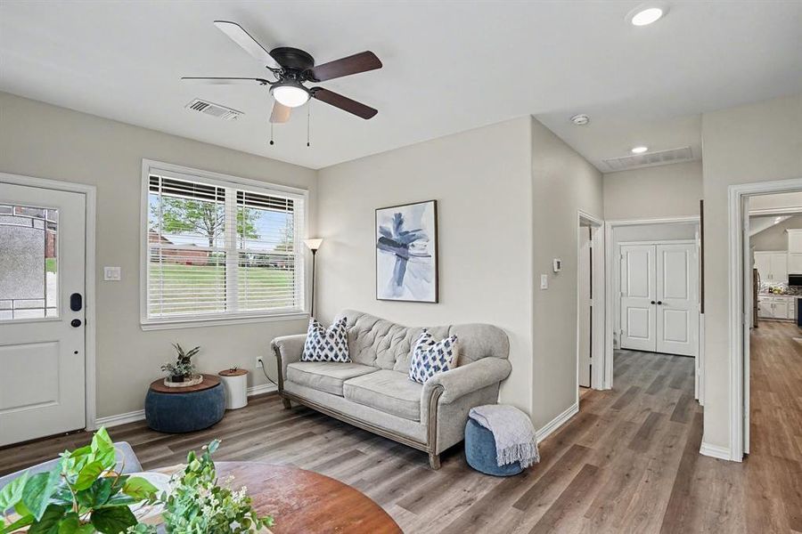 Living area with wood finished floors, ceiling fan, and recessed lighting