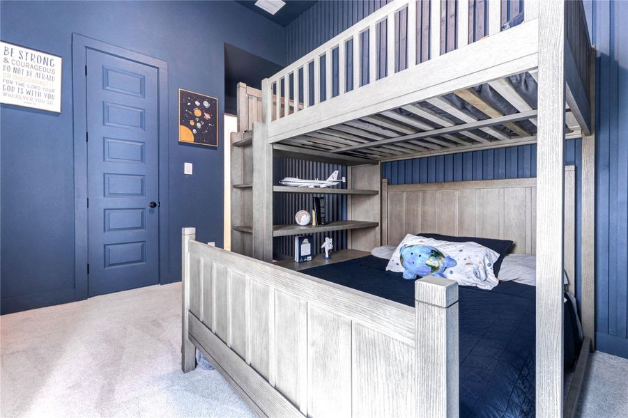 This cozy children's bedroom features a blue wall, a bunk bed with integrated shelving, and large windows for natural light. It's perfect for a playful and imaginative setup. This cozy children's bedroom features a blue wall, a bunk bed with integrated shelving, and large windows for natural light. It's perfect for a playful and imaginative setup.