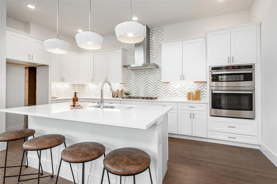 Kitchen with white cabinetry, wall chimney range hood, backsplash, stainless steel appliances, and dark hardwood / wood-style floors