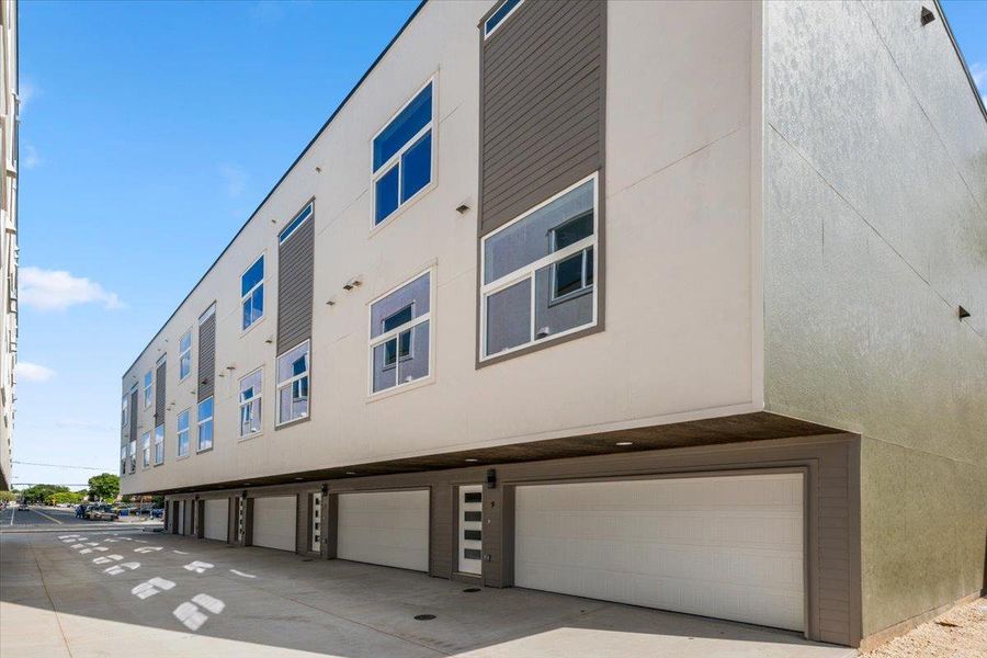 Modern architecture defines this multi-story building, offering integrated garage parking and a clean facade.