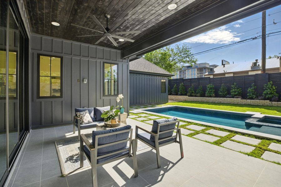 Fenced backyard with ceiling fan, a patio, an outdoor living space, and a pool with connected hot tub