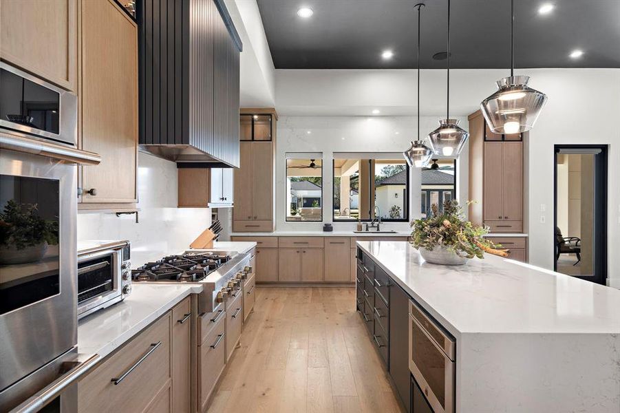 This Chefs Kitchen features premium Jenn Air Rise Series stainless appliances and paneled appliances, with stunning Quartz Countertops that also flow up the walls encasing the windows overlooking the patio and backyard