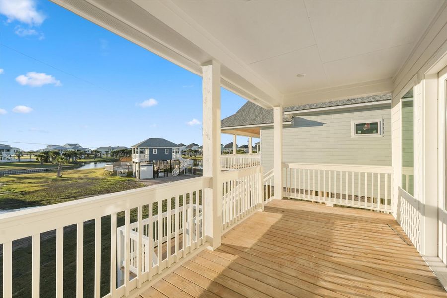 Private covered balcony overlooking green space and neighboring elevated coastal homes. Private covered balcony overlooking green space and neighboring elevated coastal homes.