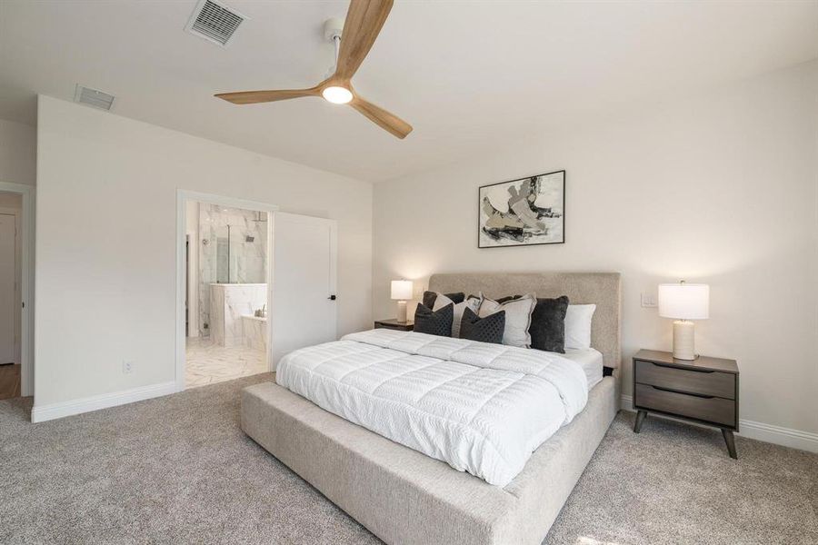 Primary Bedroom featuring carpet, ceiling fan, and connected bathroom Primary Bedroom featuring carpet, ceiling fan, and connected bathroom
