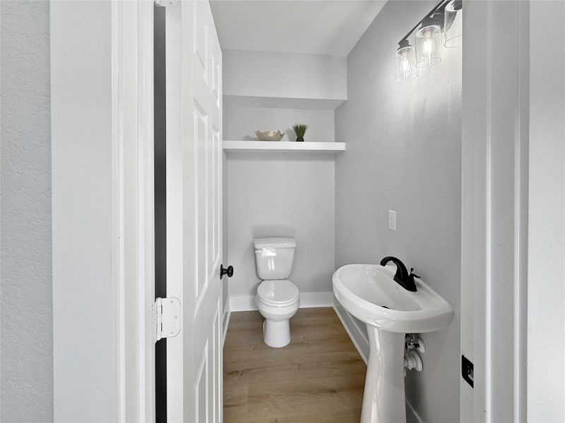 Half bath on the first floor with built-in shelves, adding a chic touch.