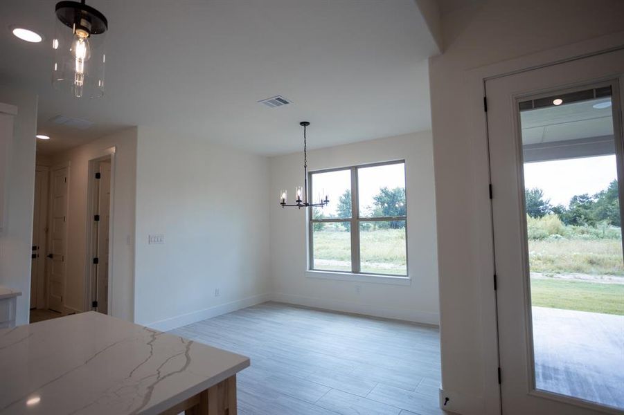 Unfurnished dining area with a chandelier, light wood-type flooring, and recessed lighting Unfurnished dining area with a chandelier, light wood-type flooring, and recessed lighting