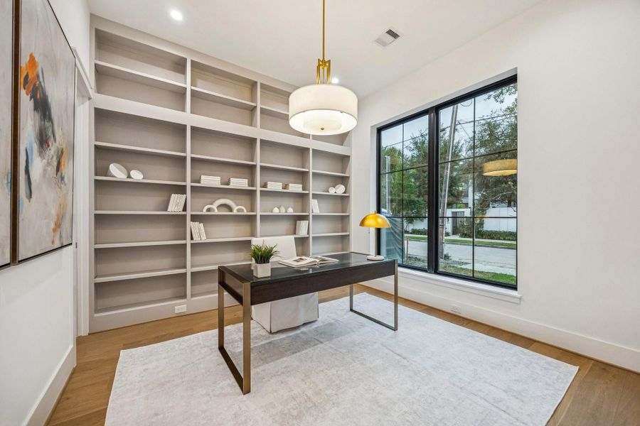 Fantastic Study just off the entrance of the home with European White Oak Plank Floors, Built-In Shelves with a custom paint color and a 24" Wide Warm Antique Brass Drum Pendant Light.