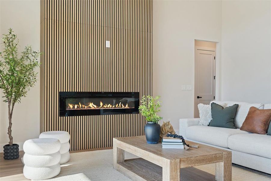 Living area with a glass covered fireplace and wood finished floors Living area with a glass covered fireplace and wood finished floors