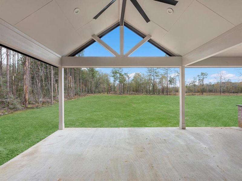 The oversized backyard patio is enhanced by an oversized black ceiling fan, and a fully equipped kitchen powered by propane.