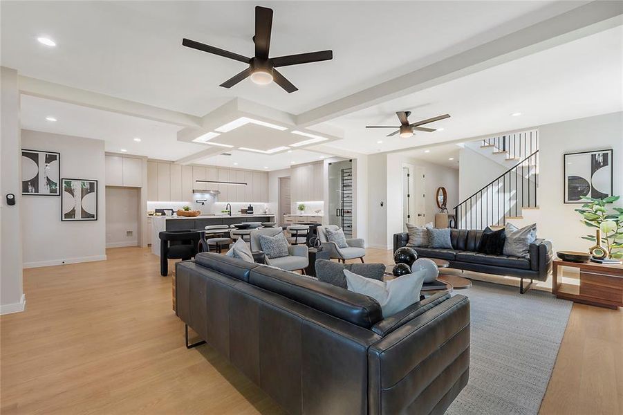 Living room featuring sink, light wood-type flooring, and ceiling fan