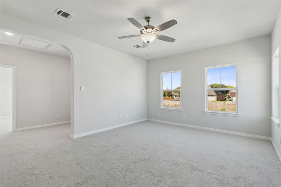 Empty room with ceiling fan and light colored carpet