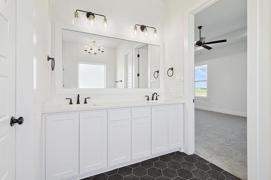 Bathroom with vanity and ceiling fan with notable chandelier