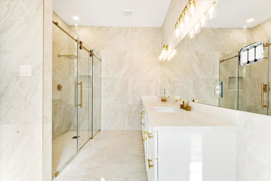 Primary bathroom featuring a walk-in shower, dual vanity, and elegant finishes. Primary bathroom featuring a walk-in shower, dual vanity, and elegant finishes.