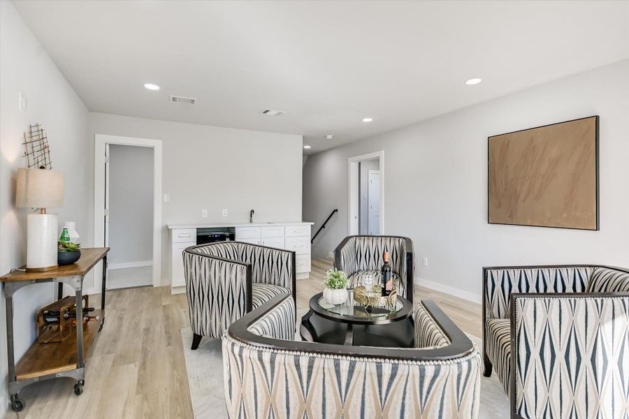 Entertain guests in this airy recreation space, complete with a convenient wet bar and recessed lighting.