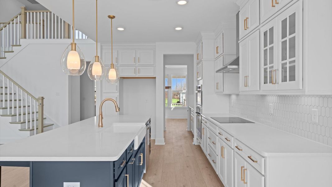 Tasteful kitchen with oversized island and stylish pendant lighting crafted to high standards