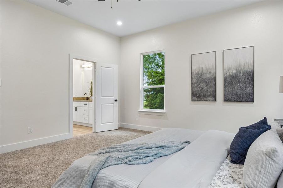Spacious room featuring neutral carpet flooring, recessed lighting, and a window with exterior views