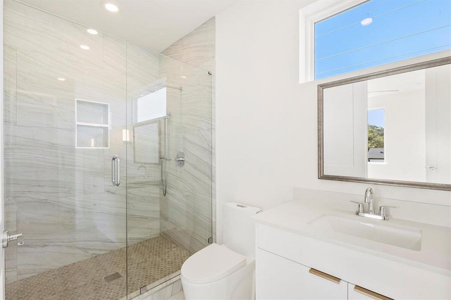 Bathroom with vanity, toilet, and a shower with door