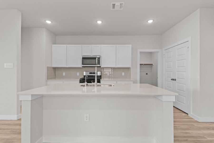A kitchen with white cabinets.