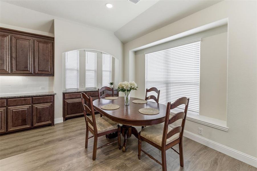 Dining area featuring vaulted ceiling, light wood-type flooring, and recessed lighting
