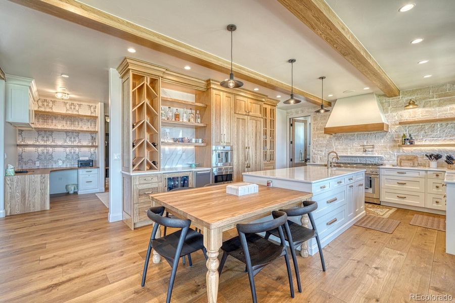 The kitchen is a showpiece of both style and performance. Thermador appliances, a gas range with pot filler, farmhouse sink, and oversized island are framed by custom oak cabinetry, marble countertops, and designer fixtures. The kitchen is a showpiece of both style and performance. Thermador appliances, a gas range with pot filler, farmhouse sink, and oversized island are framed by custom oak cabinetry, marble countertops, and designer fixtures.