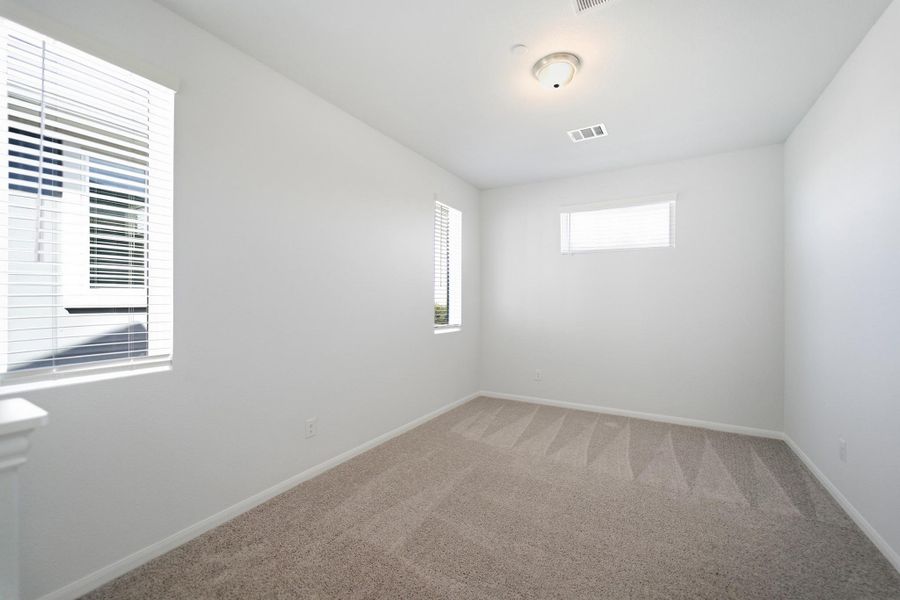 Spare room with baseboards and light colored carpet