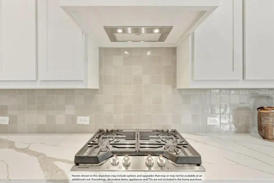 Stainless steel gas cooktop with white cabinets, marble countertop, tile backsplash, and built-in range hood above Stainless steel gas cooktop with white cabinets, marble countertop, tile backsplash, and built-in range hood above
