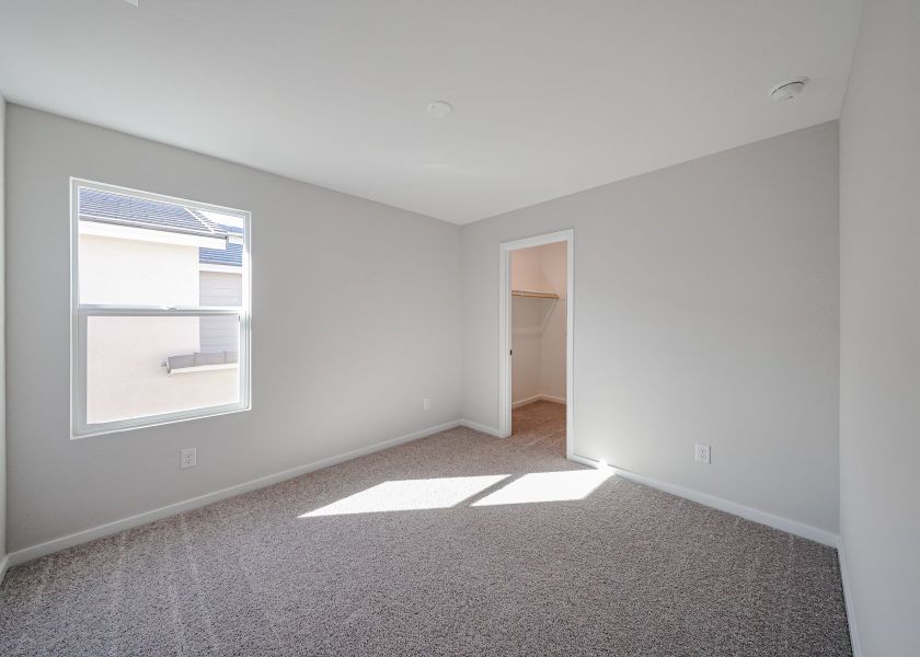 A room with a carpet and a window.