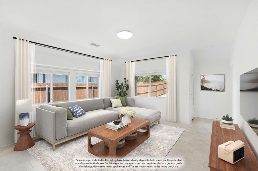 Bright living room with gray sectional sofa, wood coffee table, and large windows with white curtains
