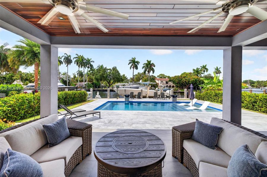 Covered patio w/ T&G ceilings, fans, fire pit seating and outdoor kitchen overlooks the gorgeous wide New River views and pool area