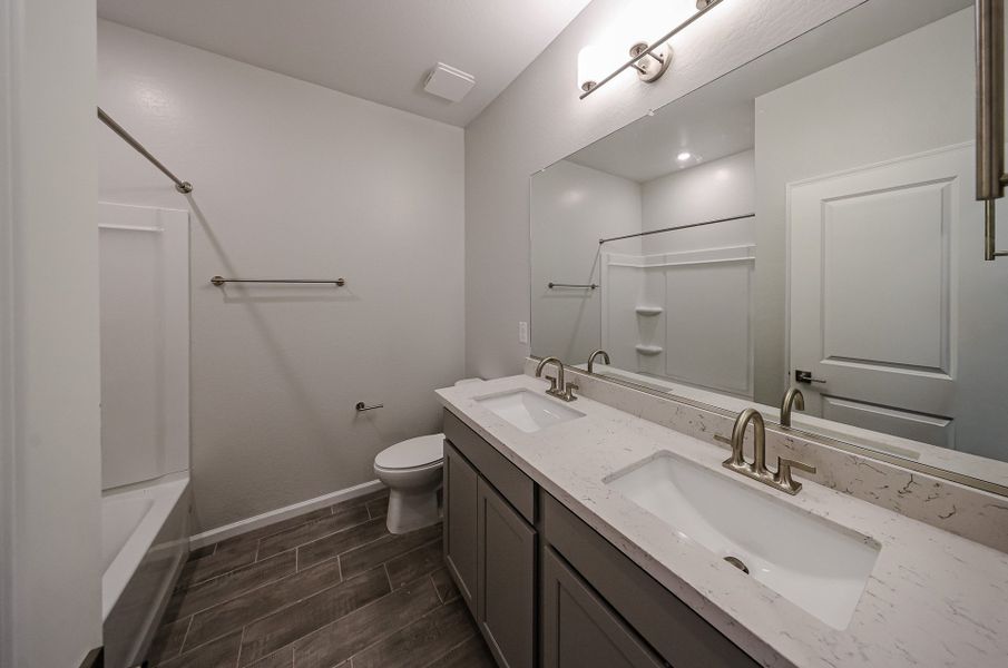 A bathroom with a sink toilet and mirror. A bathroom with a sink toilet and mirror.