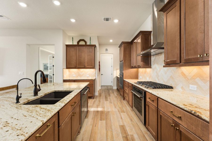 The home features a incredible kitchen loaded that is with upgrades. Kitchen upgrades include the Crescent Veil granite counters, 42" San Jacinto Maple-Chateau cabinets, Passion Crema tile backsplash, Kitchen Aid appliances, sink, and Moen Brantford High Arc Oil Rubbed Bronze faucet. The home features a incredible kitchen loaded that is with upgrades. Kitchen upgrades include the Crescent Veil granite counters, 42" San Jacinto Maple-Chateau cabinets, Passion Crema tile backsplash, Kitchen Aid appliances, sink, and Moen Brantford High Arc Oil Rubbed Bronze faucet.
