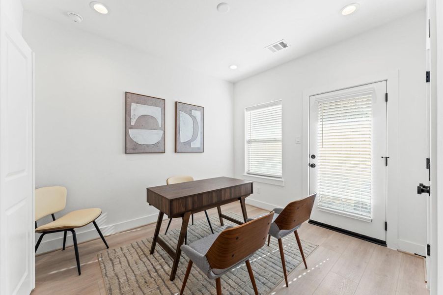 Bright and modern open-concept kitchen and dining area featuring sleek cabinetry, stainless steel appliances, and elegant pendant lighting over a spacious island.