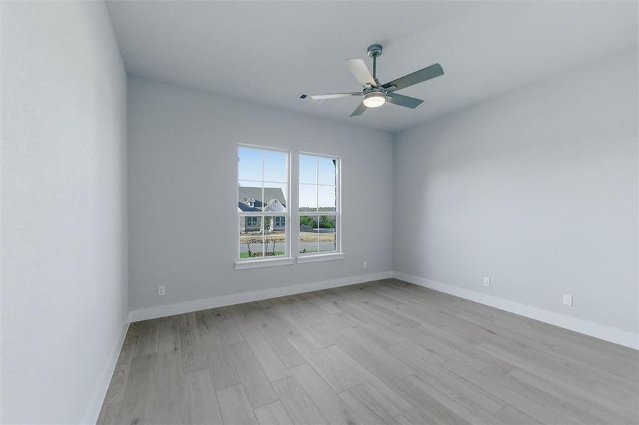 Empty room featuring a ceiling fan and light wood finished floors