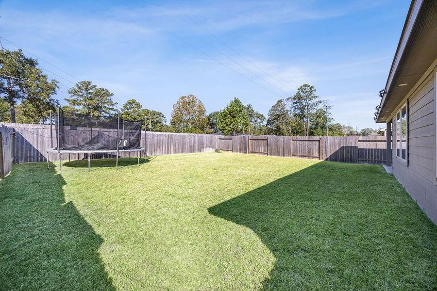 Expansive backyard featuring lush grass, perfect for relaxation and play, all within a private, fenced setting. Expansive backyard featuring lush grass, perfect for relaxation and play, all within a private, fenced setting.