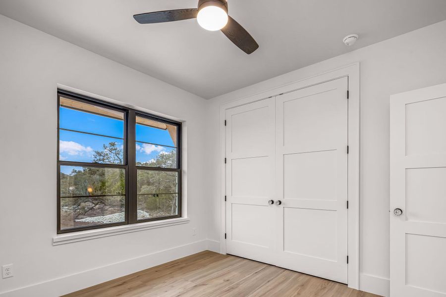 Unfurnished bedroom featuring light wood-style floors, baseboards, and a ceiling fan