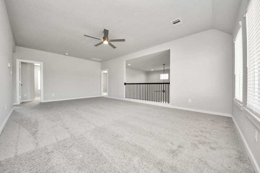 Ascend to relaxation in this fantastic game room! Ideal for both casual gatherings and adult gaming, it boasts plush carpet, lofty ceilings, custom paint, and ample windows for abundant natural light. Sample photo of completed home with similar floor plan. Actual colors and selections may vary.
