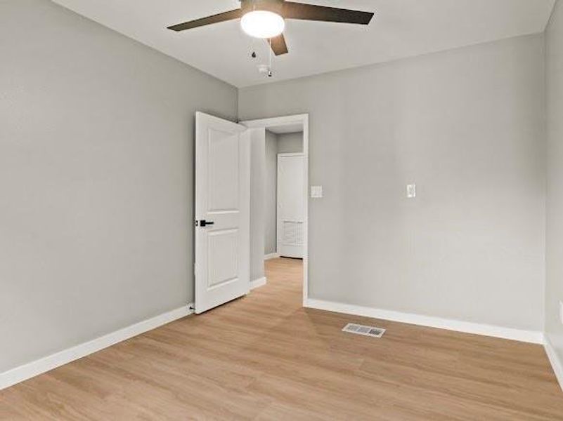 Empty room featuring light wood-style flooring and ceiling fan