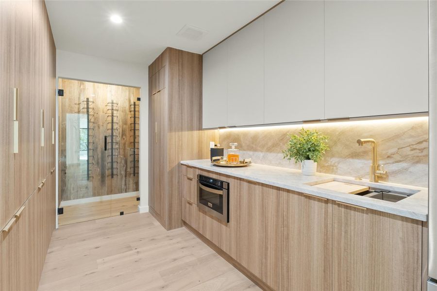 Chiefs Pantry with modern cabinets, a sink, stainless steel oven, refrigerator  and light wood-style flooring