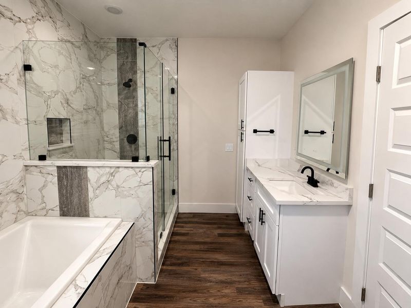 A well-appointed bath features a spacious shower, soaking tub, and a vanity with modern fixtures.