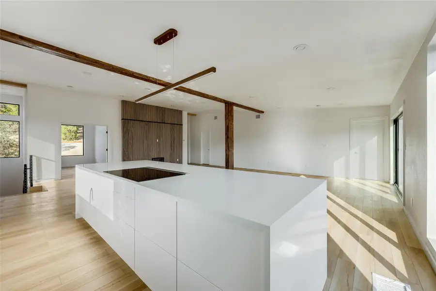 Kitchen with modern cabinets, white cabinets, open floor plan, light wood-type flooring, and a spacious island Kitchen with modern cabinets, white cabinets, open floor plan, light wood-type flooring, and a spacious island