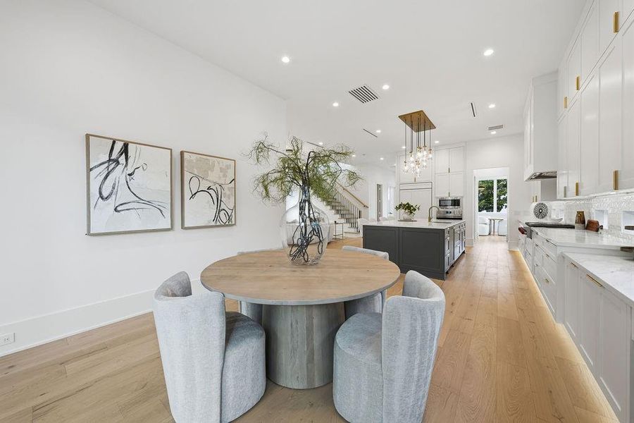 A Sun-Drenched Morning Retreat:Adjacent to the gourmet kitchen,  this open-concept breakfast area serves as a versatile space for morning coffee or informal family meals. The space features a continuous run of quartz countertops that provide a perfect secondary serving station or built-in desk nook.