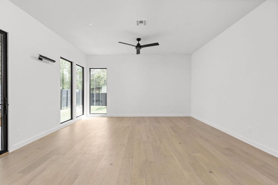 Empty room featuring ceiling fan and light wood finished floors
